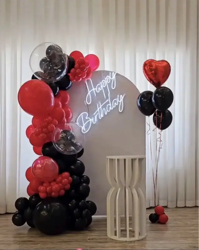 تم قرمز و مشکی لوکس با بادکنکهای قلبی قرمز، بالونهای شفاف و نوشته نئونی Happy Birthday"